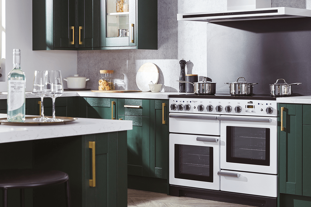 White Falcon induction top oven in a modern kitchen with green cabinetry and brass handles.