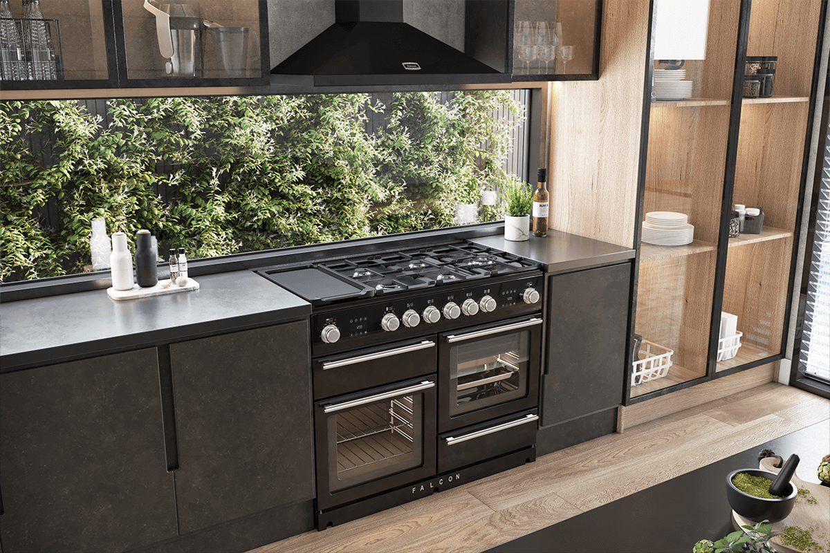 FL Bone Falcon Nexus Steam 110 Dual fuel in Black with satin chrome trim with black Falcon hood oven in a modern kitchen with a window looking out to lush greenery. 