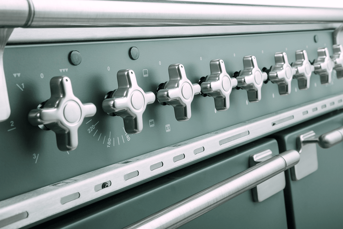 Detailed shot of a Falcon Elise cooker in mineral green colour, with its unique cross shaped brushed nickel knobs.