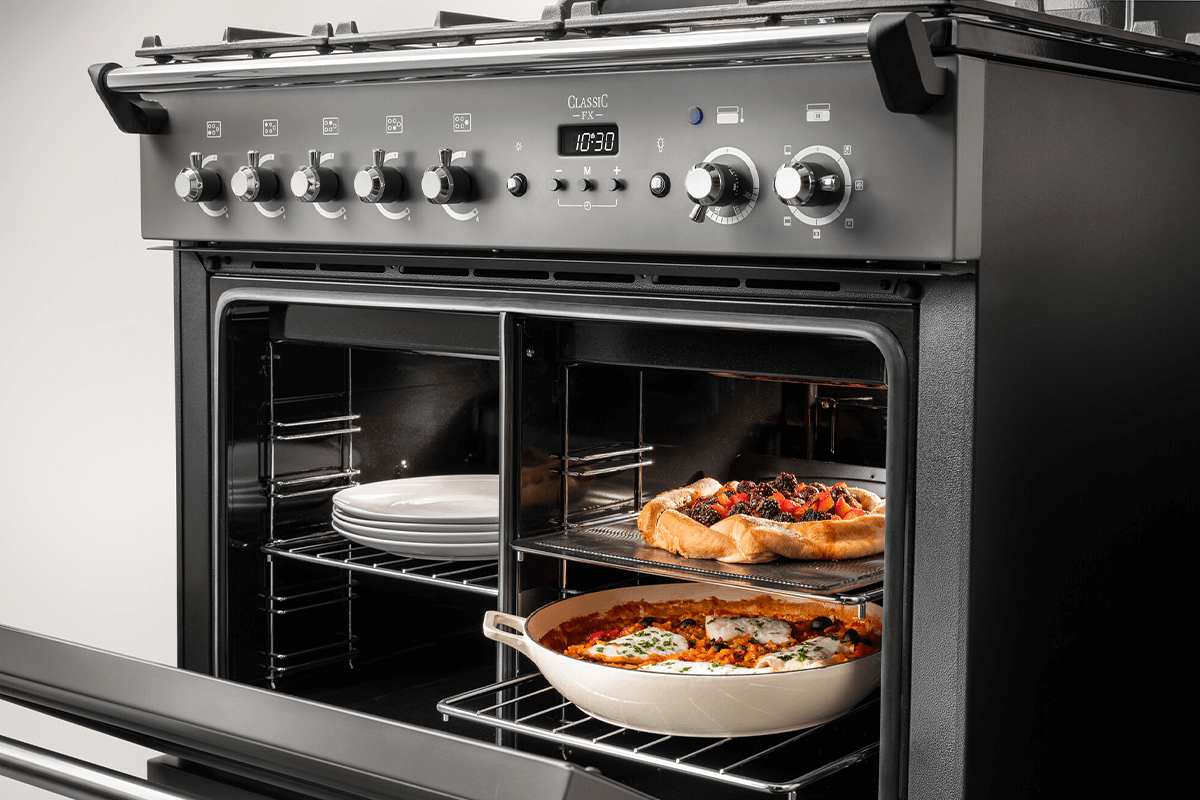 A black Falcon Professional 90 Oven has its door open with the Energy Saving Panel (ESP) in place showing how you can divide the oven. 